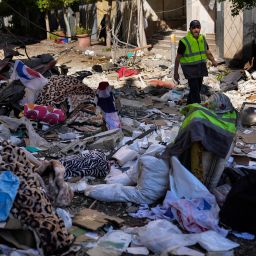 A Hezbollah paramedic walks between debris after an airstrike hit an apartment in a multistory building, in central Beirut, Lebanon, Thursday, Oct. 3, 2024. (AP Photo/Hussein Malla)