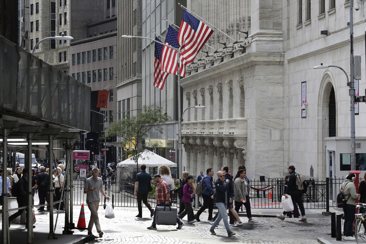 People pass the New York Stock Exchange on October 1.