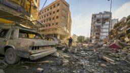 Residents run for cover following an Israeli airstrike in Dahiyeh, Beirut, Lebanon, Friday, Oct. 4, 2024. (AP Photo/Hassan Ammar)