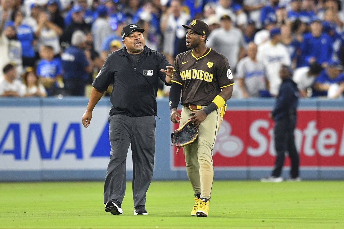 Padres outfielder Jurickson Profar speaks with an umpire during a delay due to fans throwing items on the field.