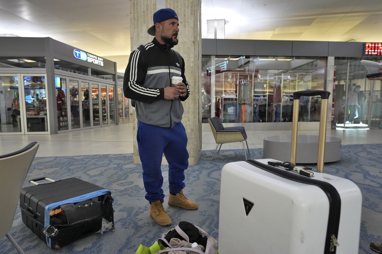 John Fedor, of New Jersey, waits for transportation help to get to a shelter after his flight was canceled on October 8, at the Tampa International Airport.