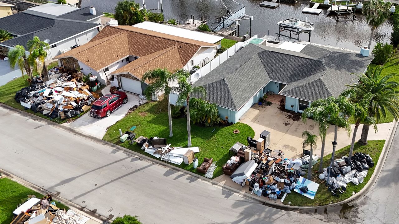 Debris from homes flooded in Hurricane Helene is piled curbside as Hurricane Milton approaches on Tuesday in Port Richey, Florida.