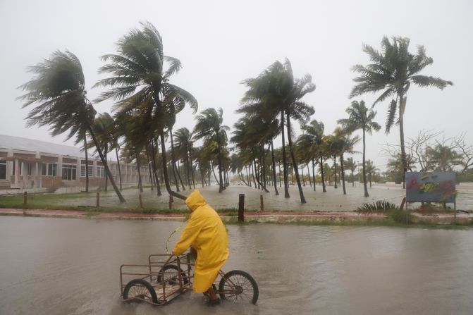 A person rides their bike through a flooded street as Hurricane Milton passes off the coast of Progreso, Yucatan Peninsula, Mexico, on Tuesday, October 8.