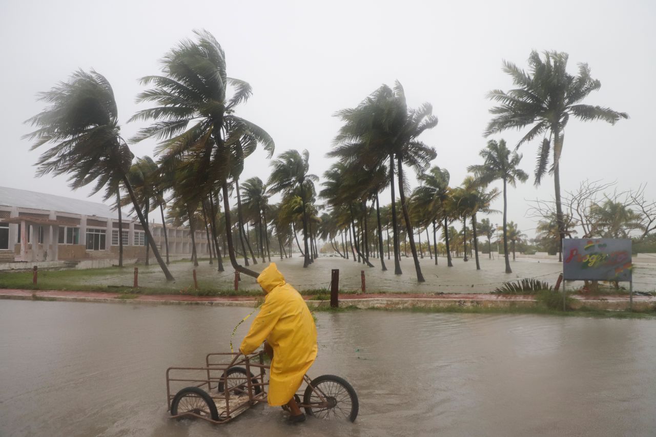 A person rides their bike through a flooded street in the rain as Hurricane Milton passes off the coast of Progreso, Yucatan state, Mexico, on October 8.