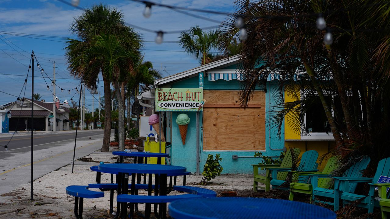 A boarded up business stands beside a deserted street in an evacuation zone on Florida's Anna Maria Island on October 8, 2024.