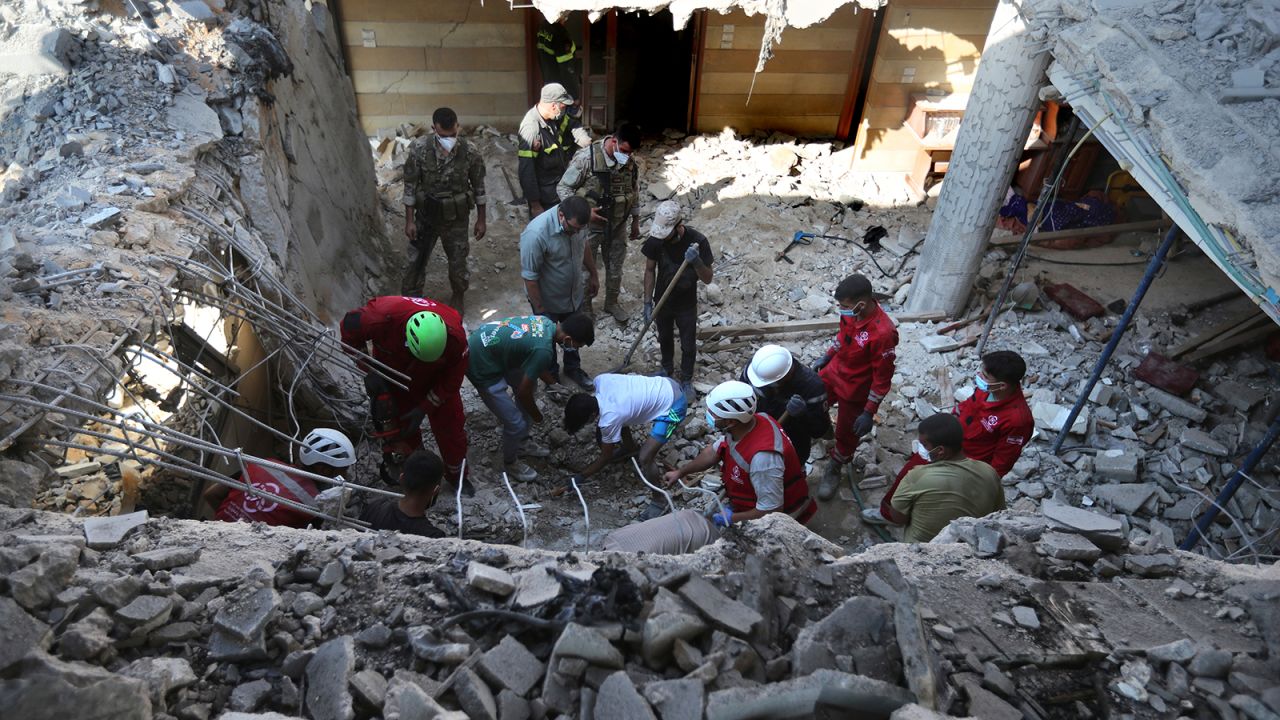 Rescue workers search for victims on a destroyed hotel-turned-shelter for displaced people hit by an Israeli airstrike, in Wardaniyeh, south Lebanon, on October 9.