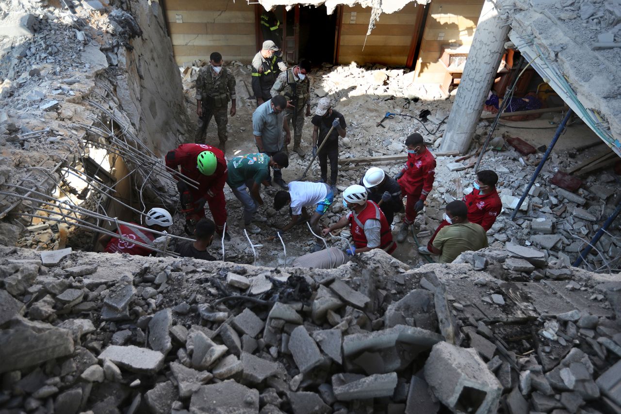 Rescue workers search for victims on a destroyed hotel-turned-shelter for displaced people hit by an Israeli airstrike, in Wardaniyeh, south Lebanon, on October 9.