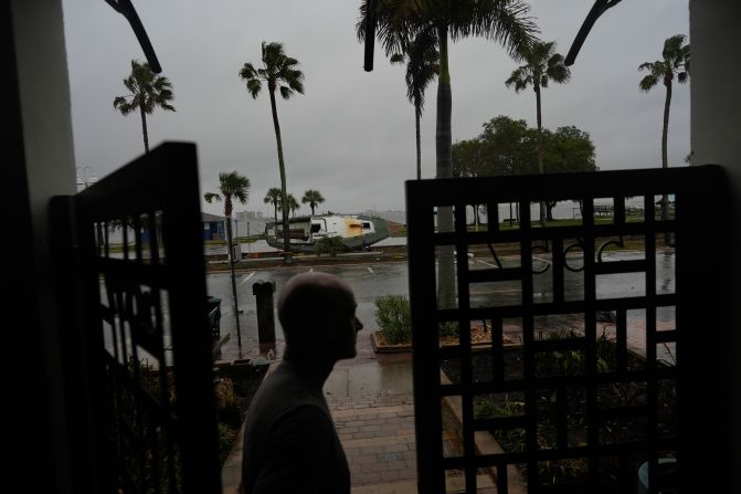 Christian Burke stands at the door of his home in Gulfport, Florida, on Wednesday. Outside, a boat sits on its side due to Hurricane Helene.