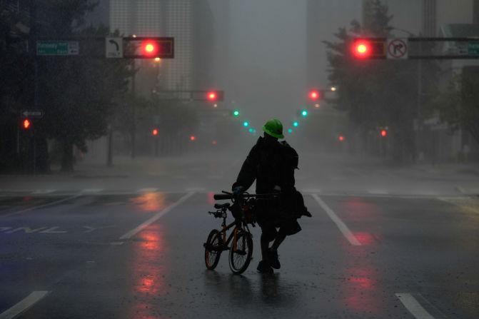 Ron Rook, who said he was looking for people in need of help or debris to clear, walks down a deserted street in downtown Tampa on Wednesday.