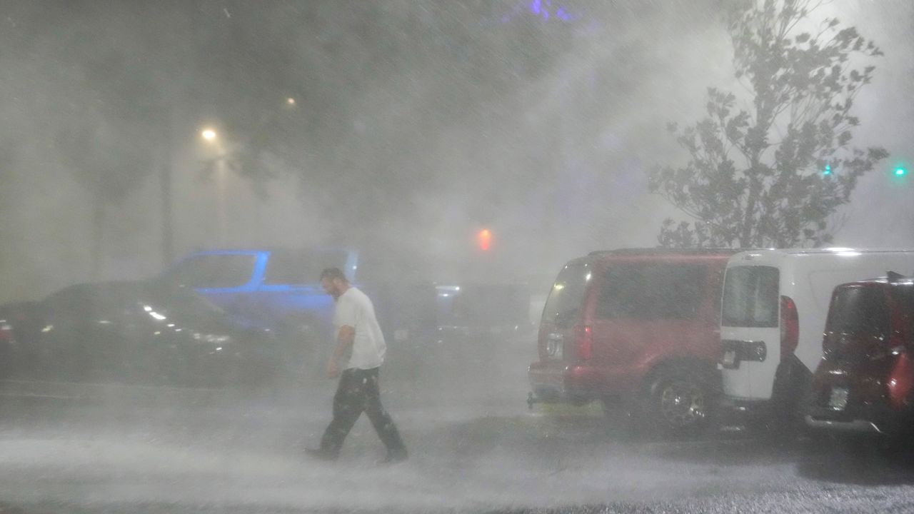 Max Watts walks in a parking lot to check on a trailer parked outside the hotel where he is riding out Hurricane Milton with coworkers, in Tampa, on Wednesday.