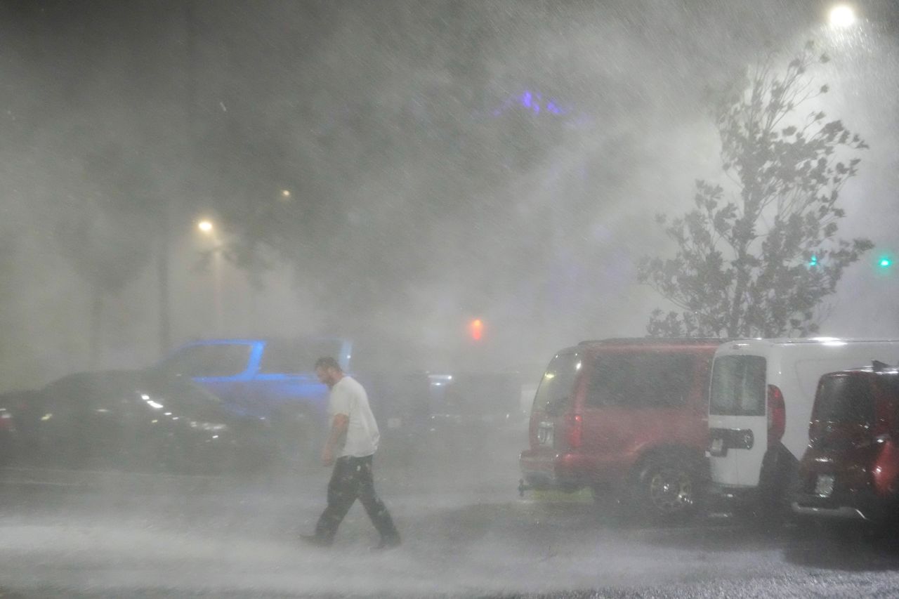 Max Watts walks in a parking lot to check on a trailer parked outside the hotel where he is riding out Hurricane Milton with coworkers, in Tampa, on Wednesday.