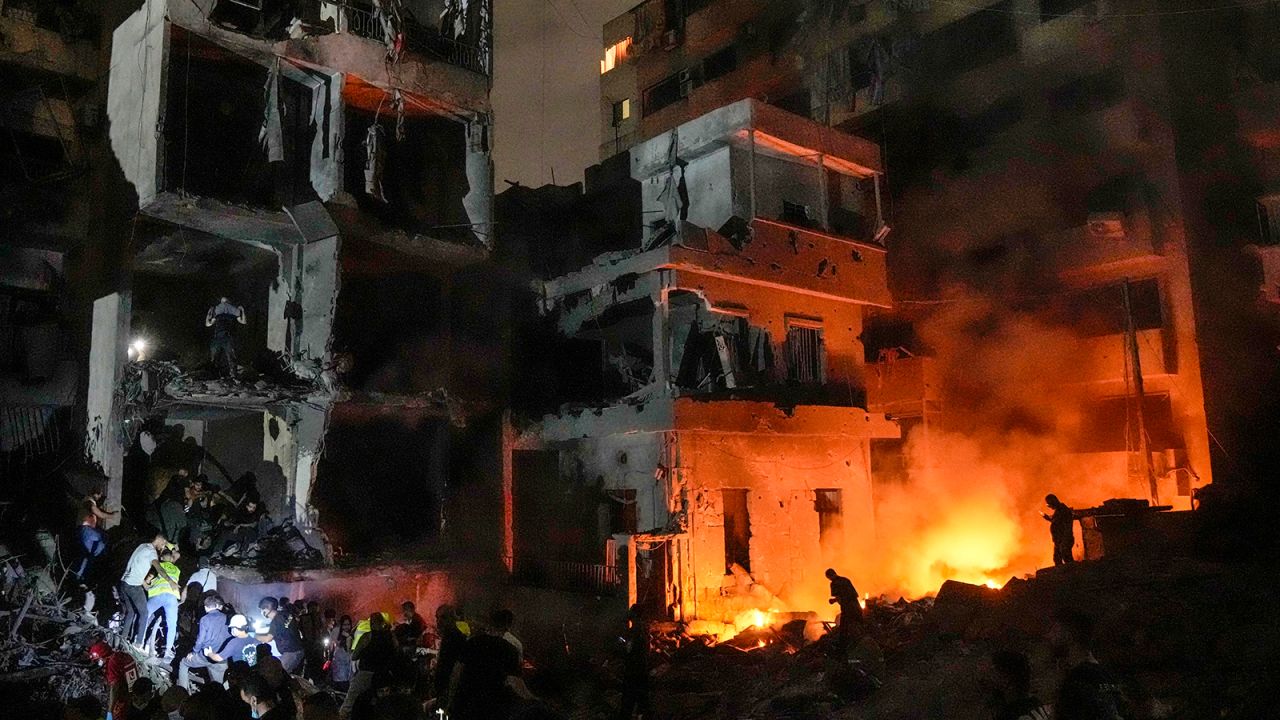 People gather in front of destroyed buildings hit by an Israeli airstrike in central Beirut, Lebanon, on October 10.