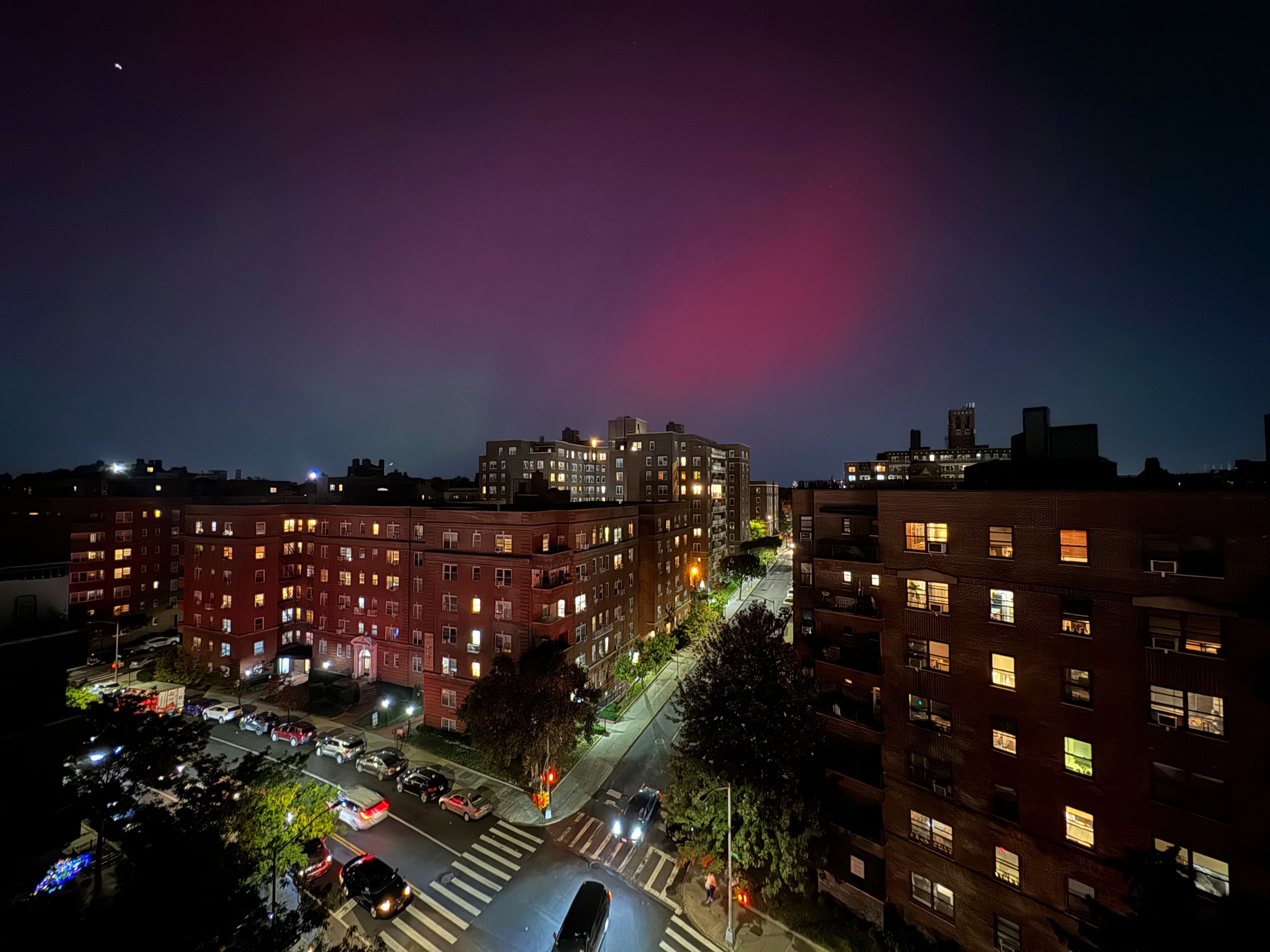 Auroras glow in the night sky above apartment buildings in the Queens borough of New York on Thursday.