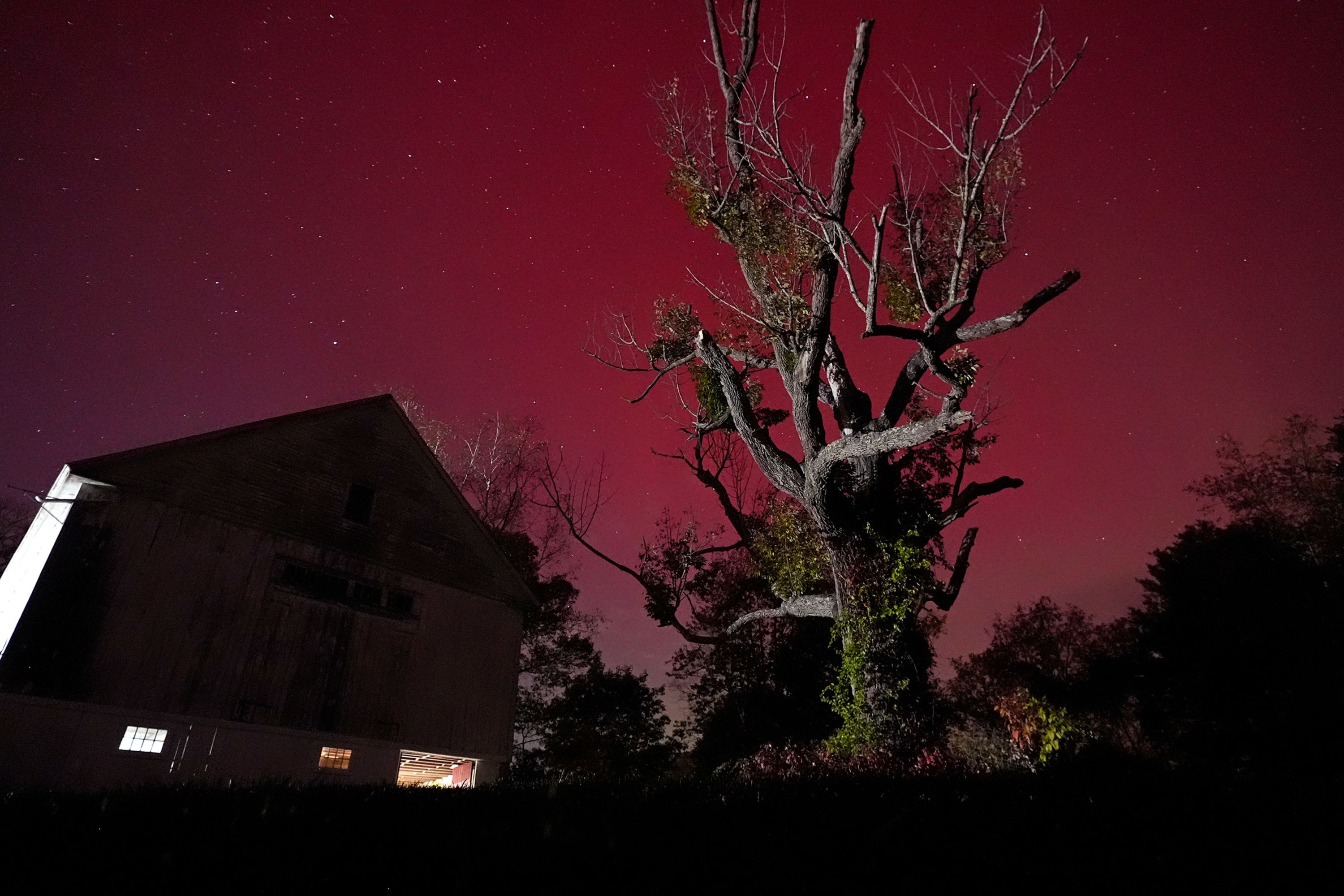 The northern lights glow red in the sky above a barn in East Derry, New Hampshire, on Thursday, October 10.