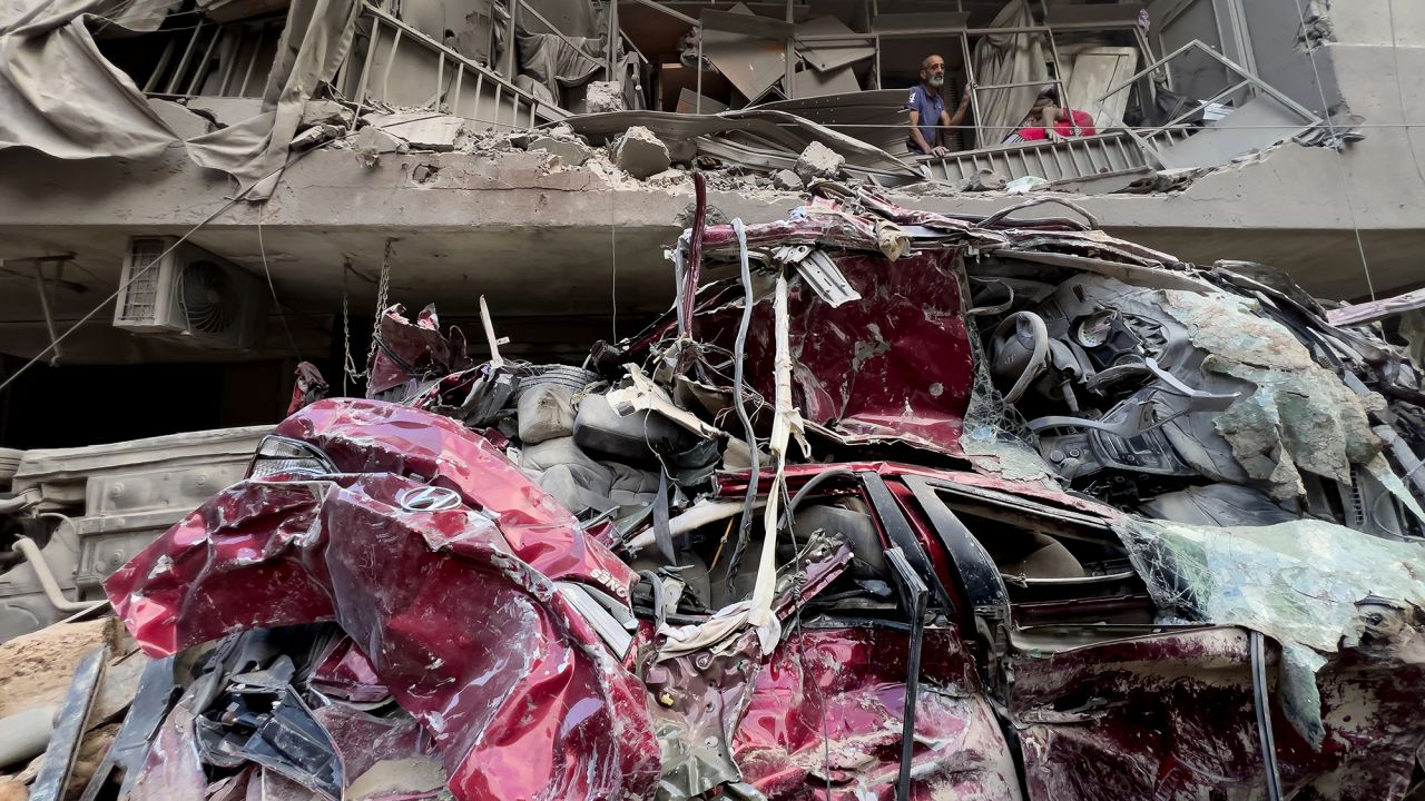 Residents remove the debris from their destroyed balcony at the site of an Israeli airstrike in Beirut, Lebanon, on October 11.