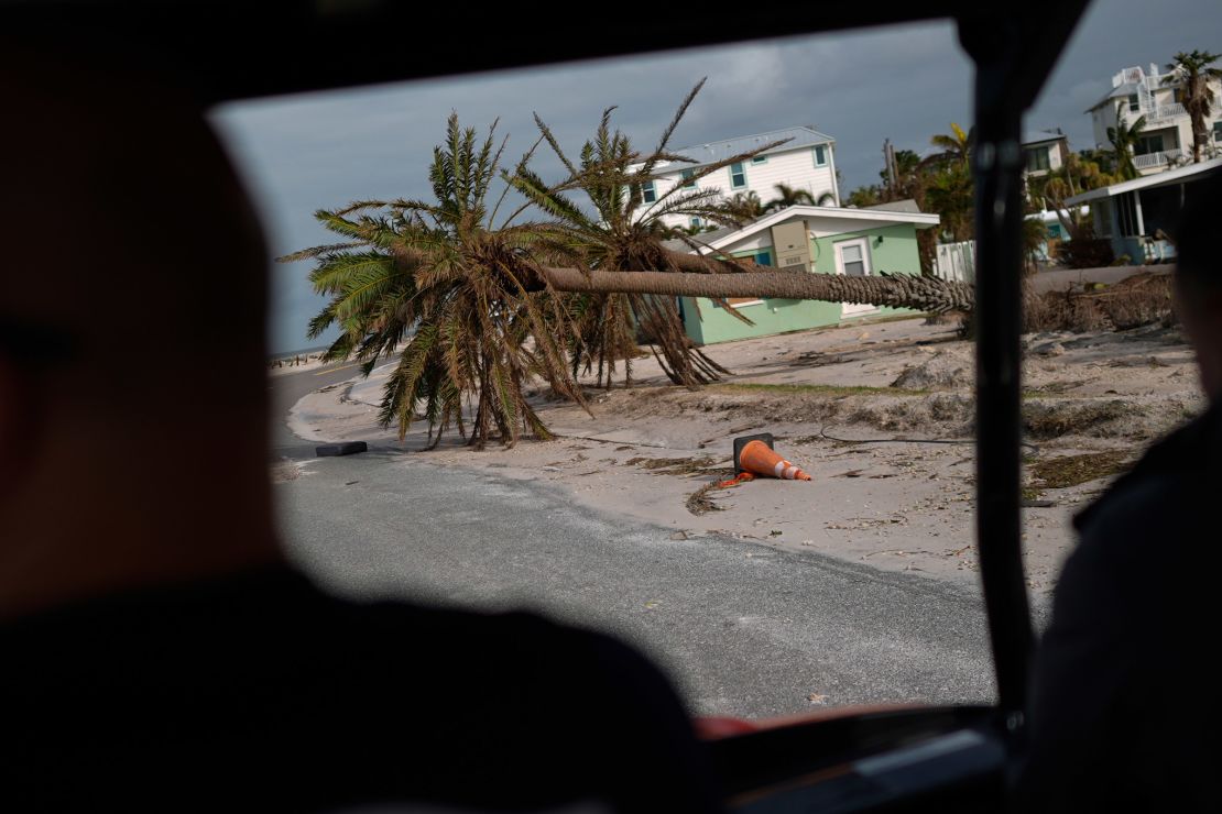 Fallen palm trees lie along a road in Bradenton Beach on Anna Maria Island, Florida, on October 10, 2024.