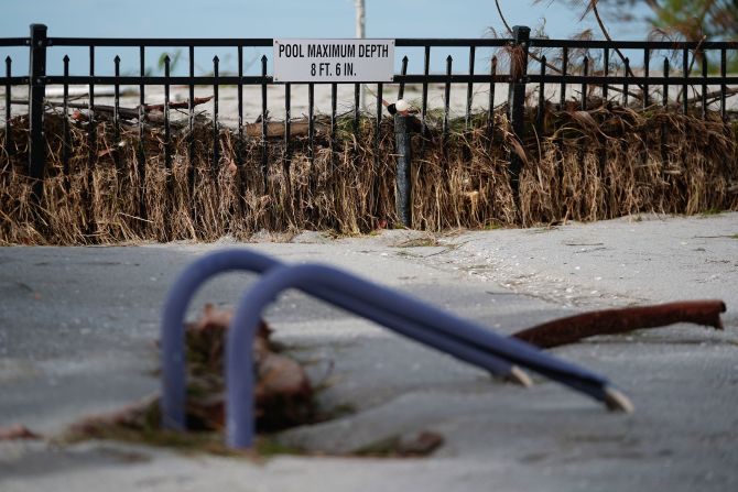 The rails of a pool ladder are all that is visible Friday of a pool that was filled with sand after the passage of Hurricane Milton in Venice, Florida.