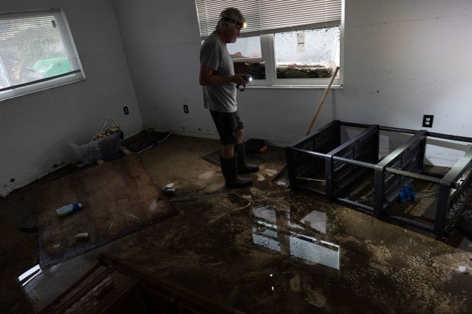 Robert Turick stands in one of his home's bedrooms, where the high water mark from Hurricane Milton can be seen on the wall, in Englewood, Florida, on Friday. A small positive, Turick said, is that he hadn't yet begun repairs after Hurricane Helene brought 3-foot flood waters, and he, his dog, and his daughter were staying elsewhere when Milton flooded his home around to 5 feet.