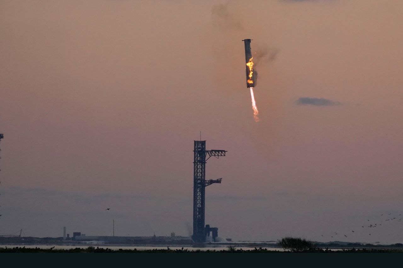 SpaceX's Super Heavy booster returns to the launch pad to be captured during a test flight on Sunday, October 13, in Boca Chica, Texas.