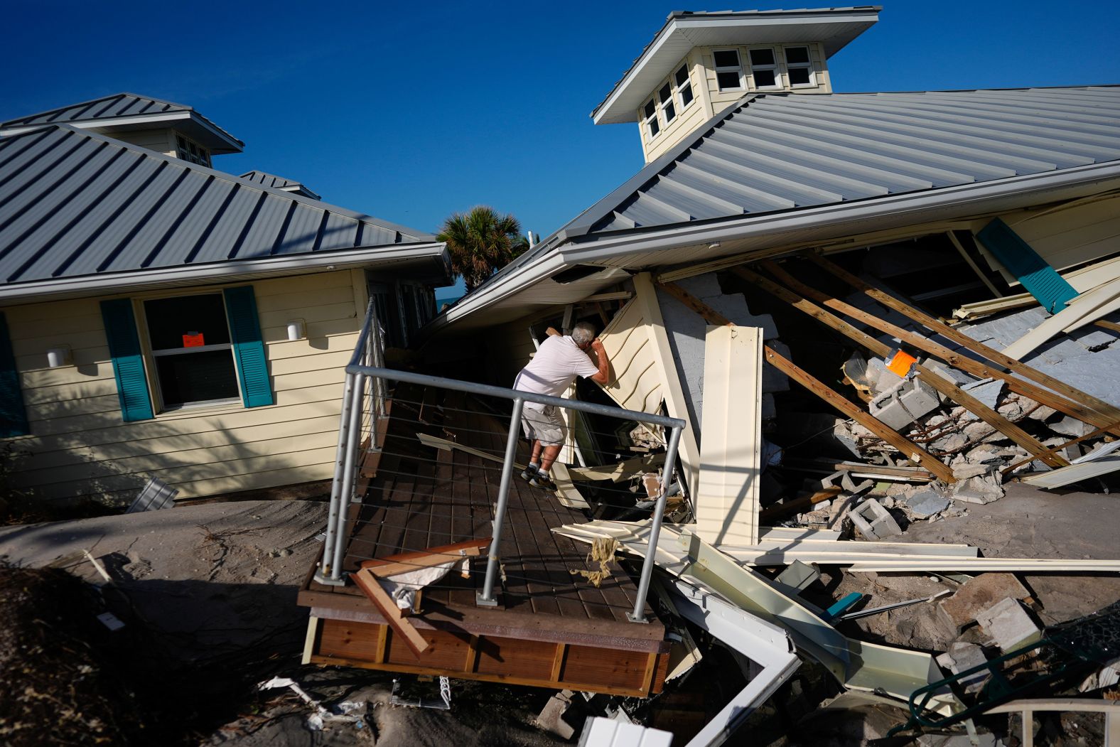 A man peers into the remains of a home on Manasota Key in Englewood, Florida, on Sunday.