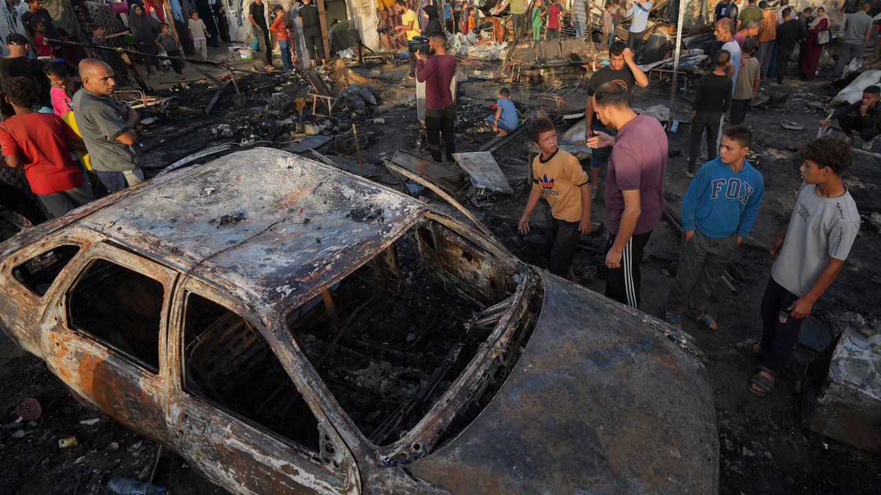 People look at the damage after an Israeli strike hit the courtyard of Al Aqsa Martyrs hospital in Deir al Balah, Gaza, on Monday.