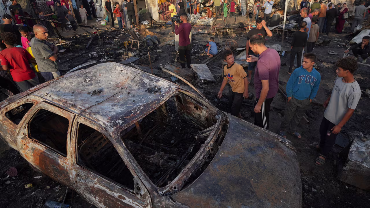 People look at the damage after an Israeli strike hit the courtyard of Al Aqsa Martyrs hospital in Deir al Balah, Gaza, on Monday.