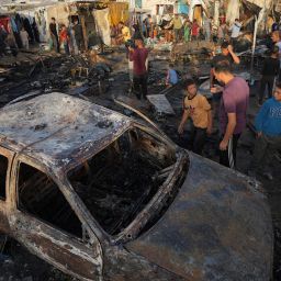 Palestinians look at the damage after an Israeli strike hit a tent area in the courtyard of Al Aqsa Martyrs hospital in Deir al Balah, Gaza Strip, Monday, Oct. 14, 2024. (AP Photo/Abdel Kareem Hana)