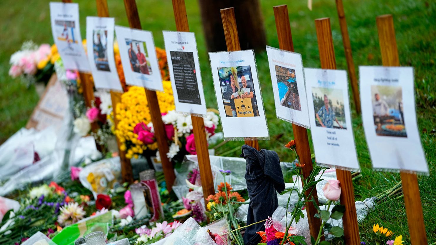 Rain-soaked memorials for those who died in a mass shooting sit along the roadside by Schemengees Bar and Grille, on October 30, 2023, in Lewiston, Maine.