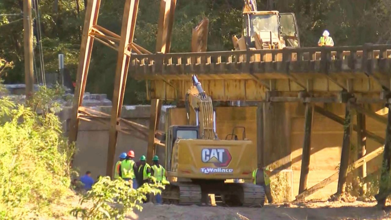 This image taken from video from CNN affiliate WLBT shows construction workers at the scene after a bridge over the Strong River in Simpson County, Mississippi, collapsed on Wednesday, October 16, 2024.