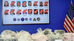 Canadian former Olympic snowboarder Ryan Wedding, 43, who is a fugitive, is seen top left, with 15 other defendants who have been charged in a 16-count superseding indictment for allegedly running and participating in a transnational drug trafficking operation that routinely shipped hundreds of kilograms of cocaine, from Colombia, through Mexico and Southern California, to Canada and other locations in the United States, are displayed on a video monitor as federal, local, and international officials announce federal charges and arrests of alleged members at a news conference at the FBI offices in Los Angeles, Thursday, Oct. 17, 2024. (AP Photo/Damian Dovarganes)
