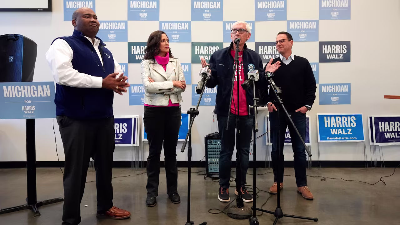 Chair of the Democratic National Committee Jaime Harrison, left, Michigan Gov. Gretchen Whitmer, Wisconsin Gov. Tony Evers and Pennsylvania Gov. Josh Shapiro talk to volunteers during a campaign event in Flint, Michigan, on October 17.