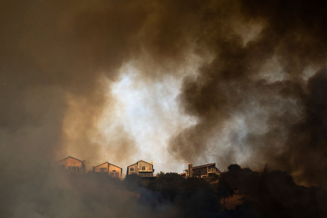 Smoke rises above homes as a fire burns near Interstate 580 in Oakland, California, on October 18.