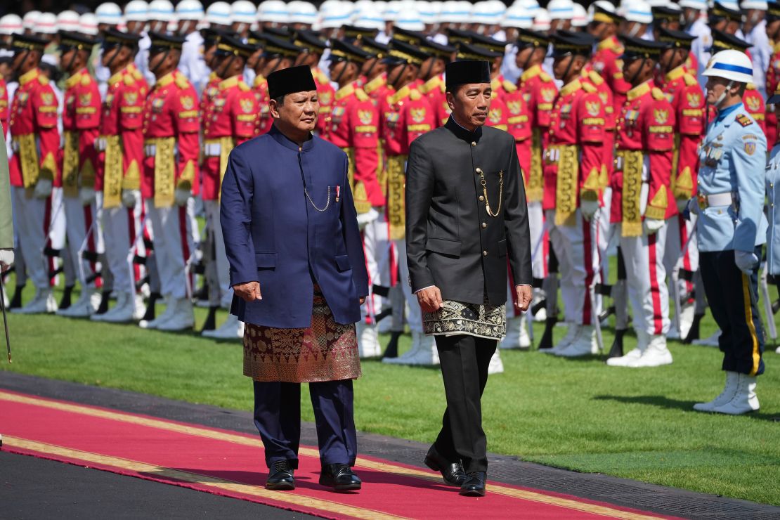 Le nouveau président indonésien Prabowo Subianto, à gauche, et son prédécesseur Joko Widodo inspectent la garde d'honneur lors de leur cérémonie de passation de pouvoir au palais Merdeka à Jakarta, en Indonésie, le 20 octobre 2024.