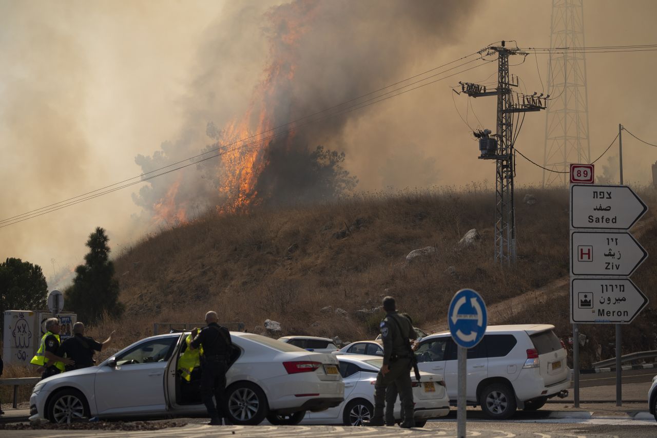 Members of the Israeli forces watch a fire after a rocket, fired from Lebanon, hit an area near Rosh Pinna, Israel, on October 20.