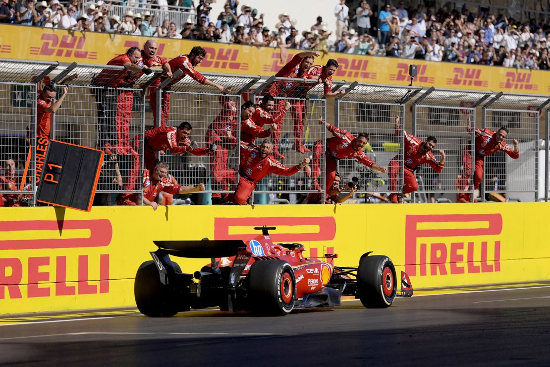 Team members stand along the fence celebrating as Leclerc wins the US Grand Prix.