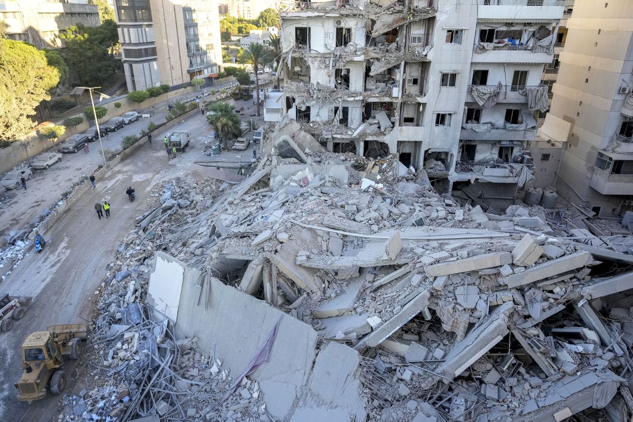 Rescue workers use a bulldozer to remove rubble at the site of an Israeli airstrike on Sunday night that hit several branches of the Hezbollah run Al-Qard Al-Hassan Association in Beirut, Lebanon, on October 21.