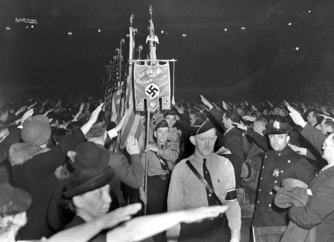 The crowd responds with a Hitler salute as uniformed members of a German-American League color guard march to a meeting at Madison Square Garden on February 20, 1939.