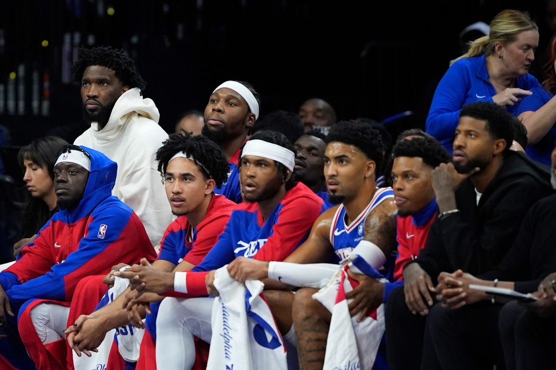 Joel Embiid of the Philadelphia 76ers (top left) watches the 76ers game from the bench. Embiid missed the game with a left knee injury.