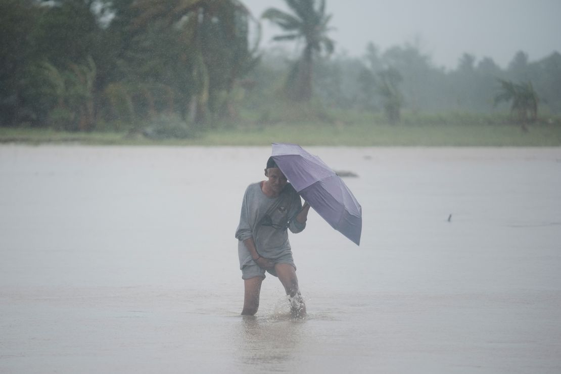 A man crosses a flooded rice field as Trami dumped heavy rains at Libon town, Albay province, Philippines on October 24, 2024.