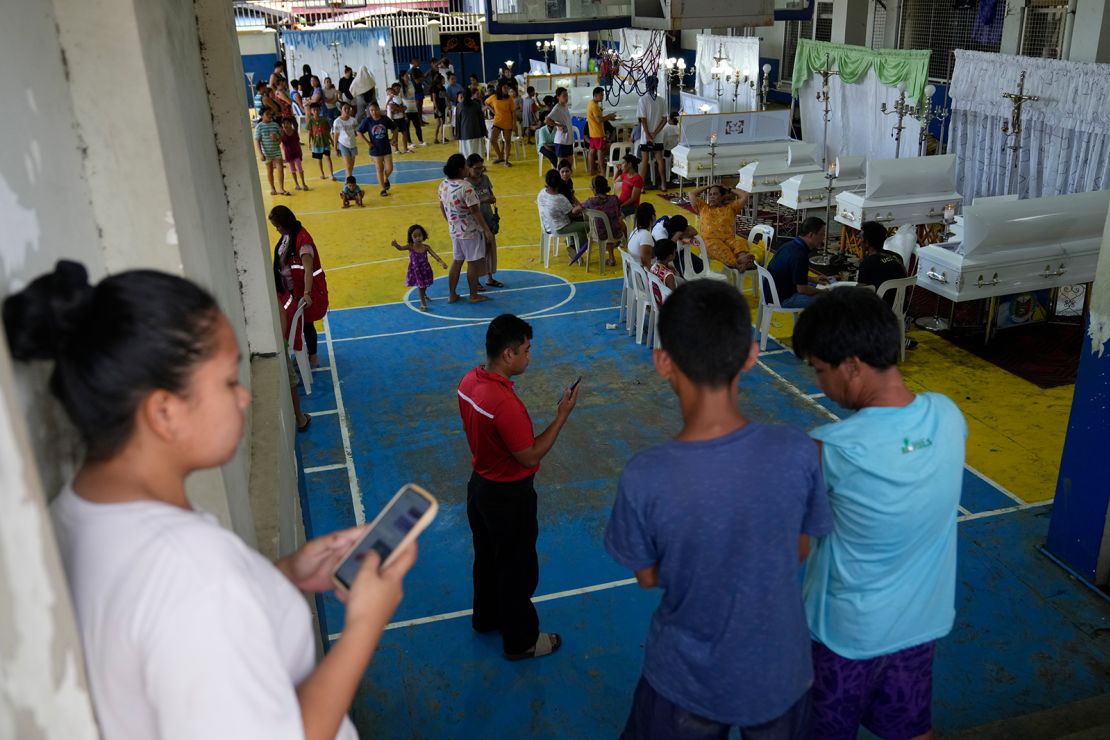 Villagers gather to pay respects to family and friends who died after a landslide hit their homes triggered by Tropical Storm Trami, in Talisay, Batangas province on October 26, 2024.