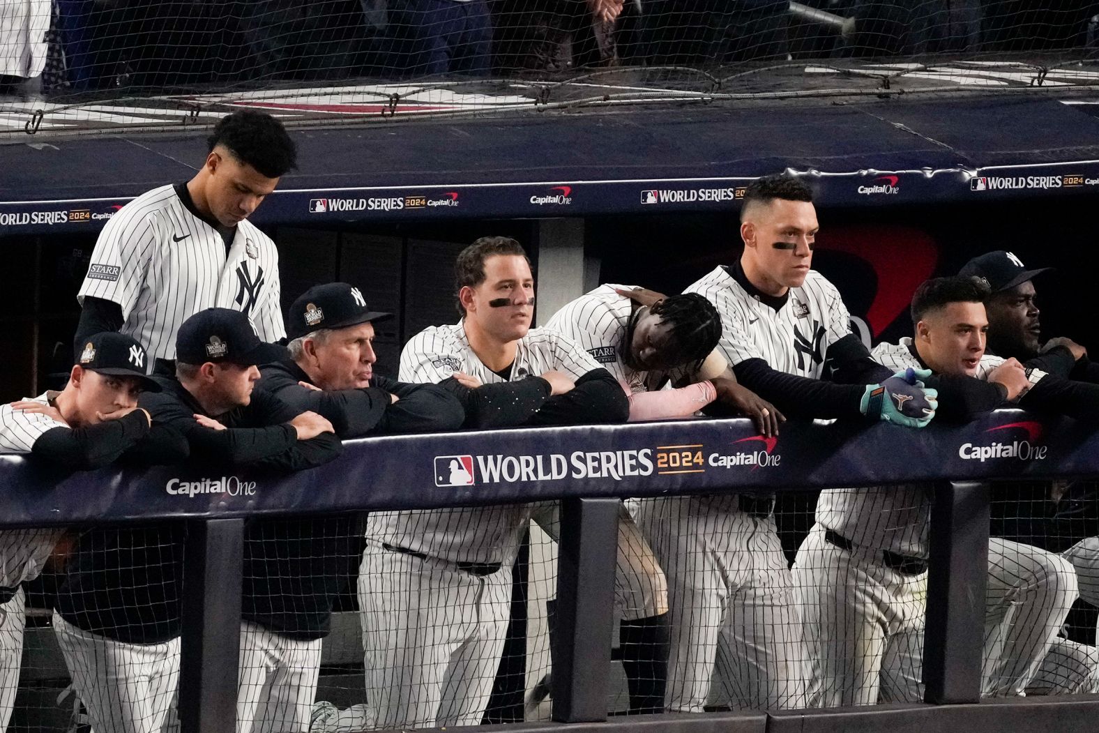 Dejected Yankees watch from the dugout after the final pitch Wednesday.