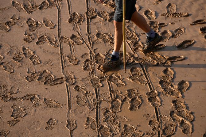 A man walks on a mud-covered road in Valencia on Thursday.