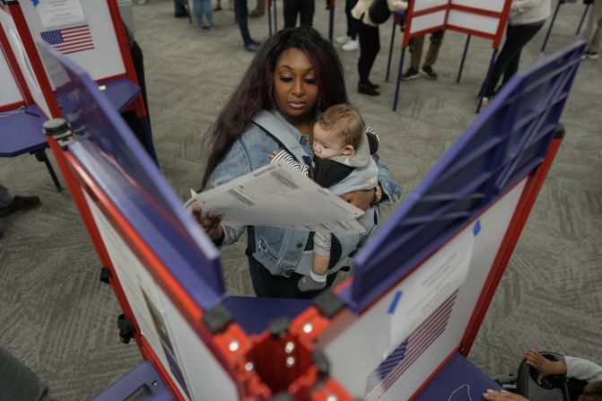 First-time voter Kayria Hildebran holds her baby, Kayden, as she fills out her ballot in Cincinnati on Thursday.