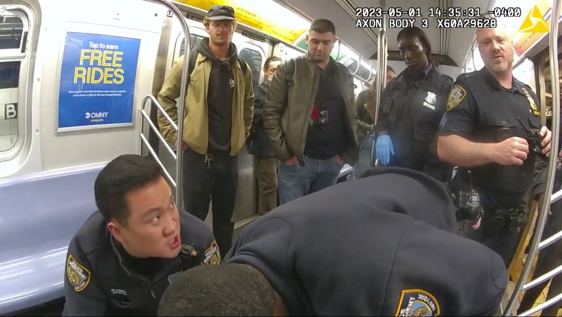 Daniel Penny, left, looks on in a New York City subway car as officers attempt to revive Jordan Neely in May 2023.