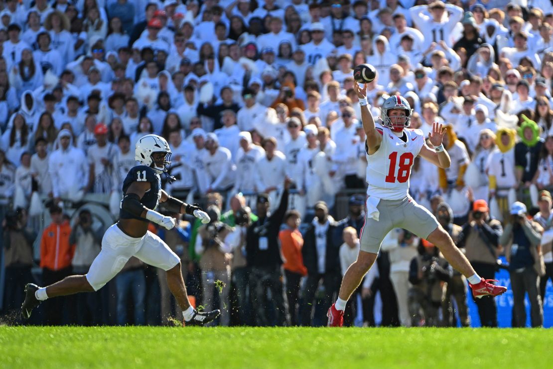 Ohio State quarterback Will Howard throws a pass while being pressured by Penn State defensive end Abdul Carter.