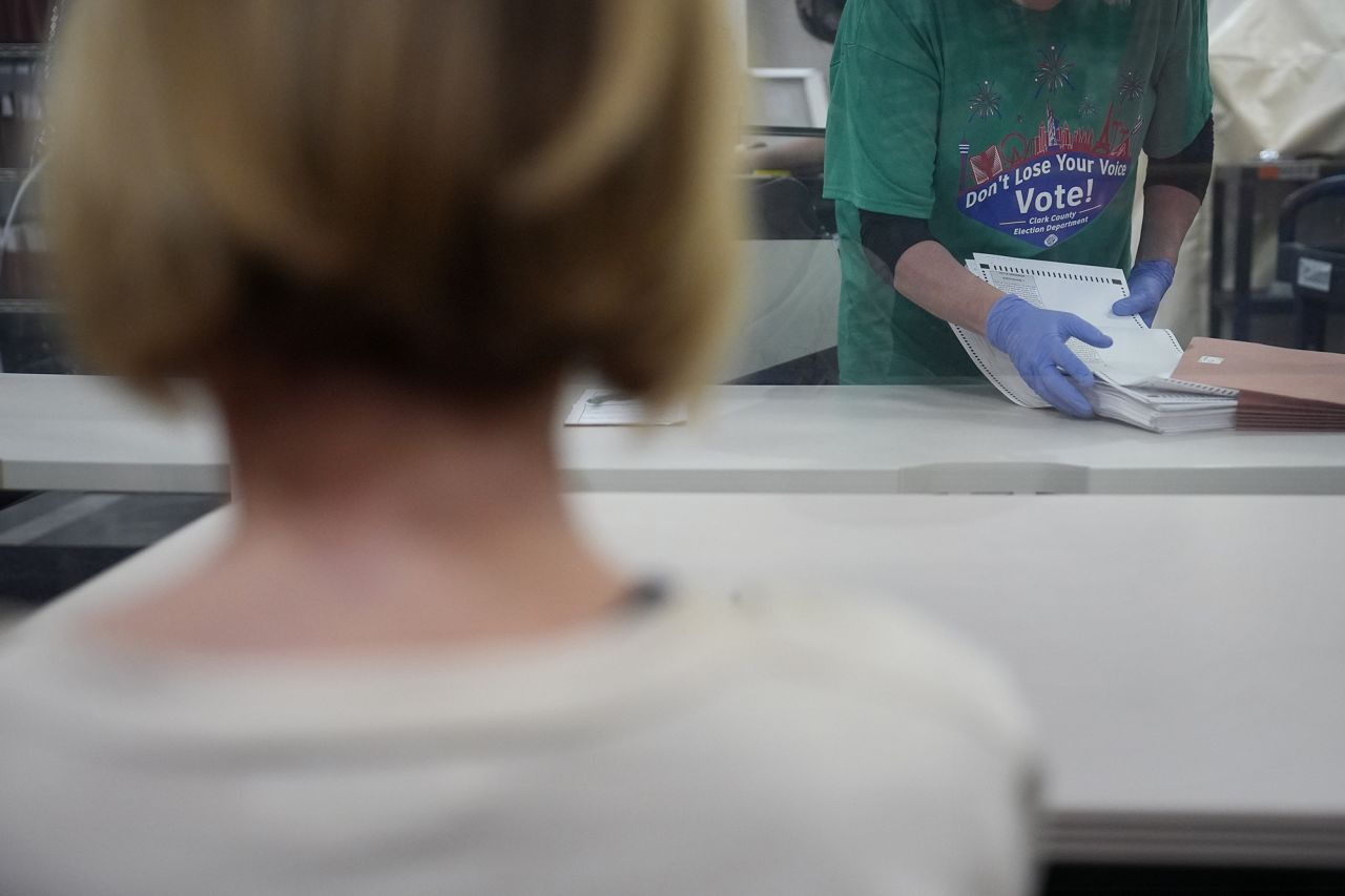 A county worker puts ballots into a folder after scanning at a tabulating area at the Clark County Election Department, on Saturday, November 2 in North Las Vegas, Nevada.