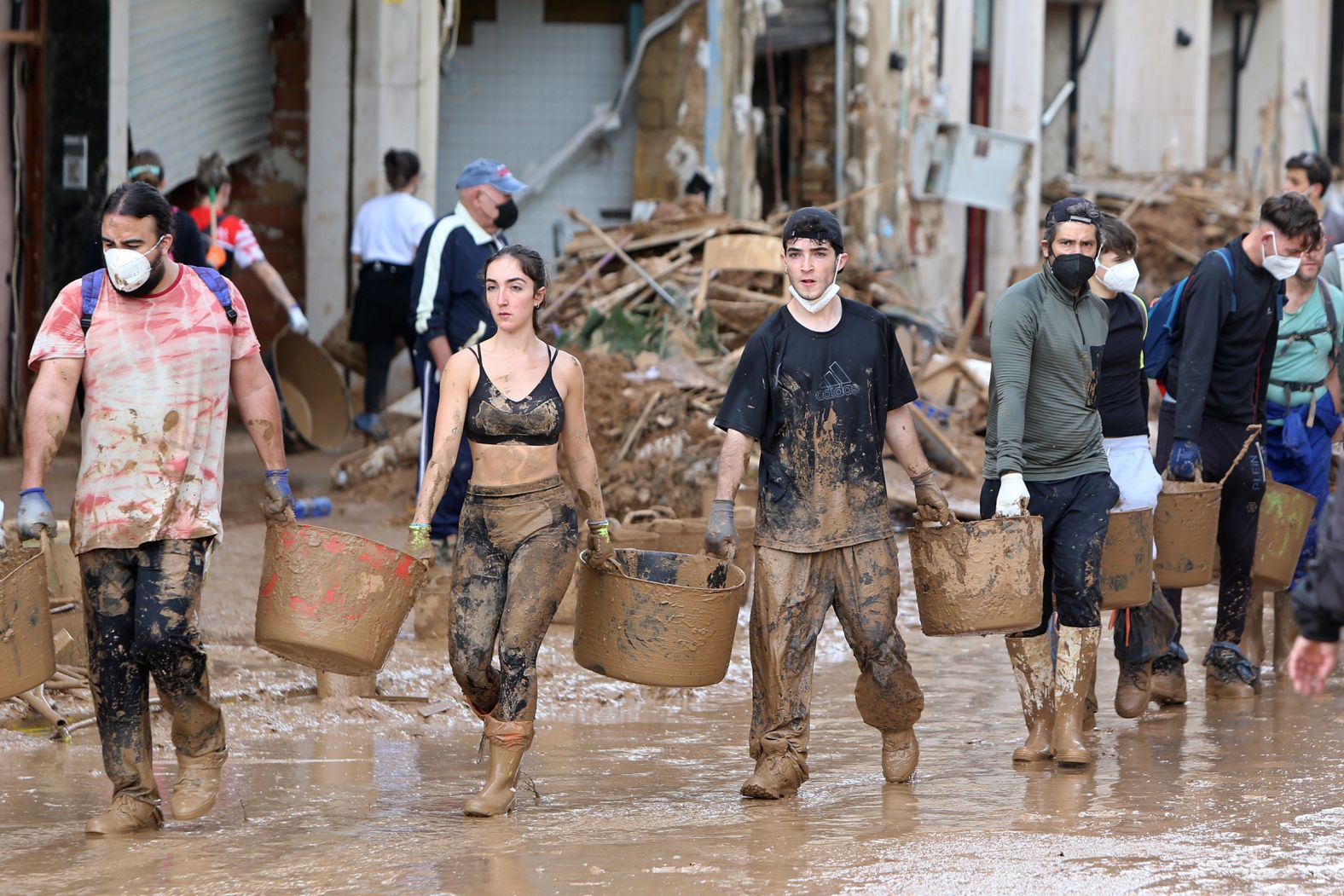 Volunteers in Paiporta carry buckets of mud on Sunday.