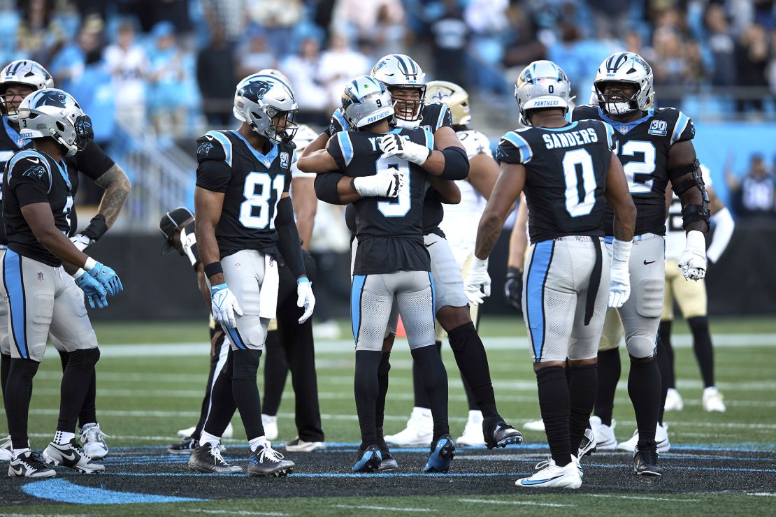 Young (No. 9) and Robert Hunt (No. 50) embrace after the win against the Saints.