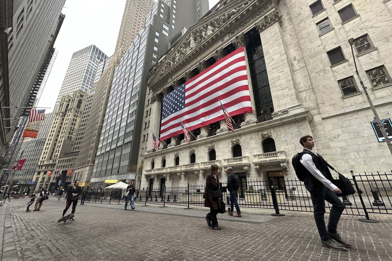 People pass the New York Stock Exchange in New York's Financial District on November 5.