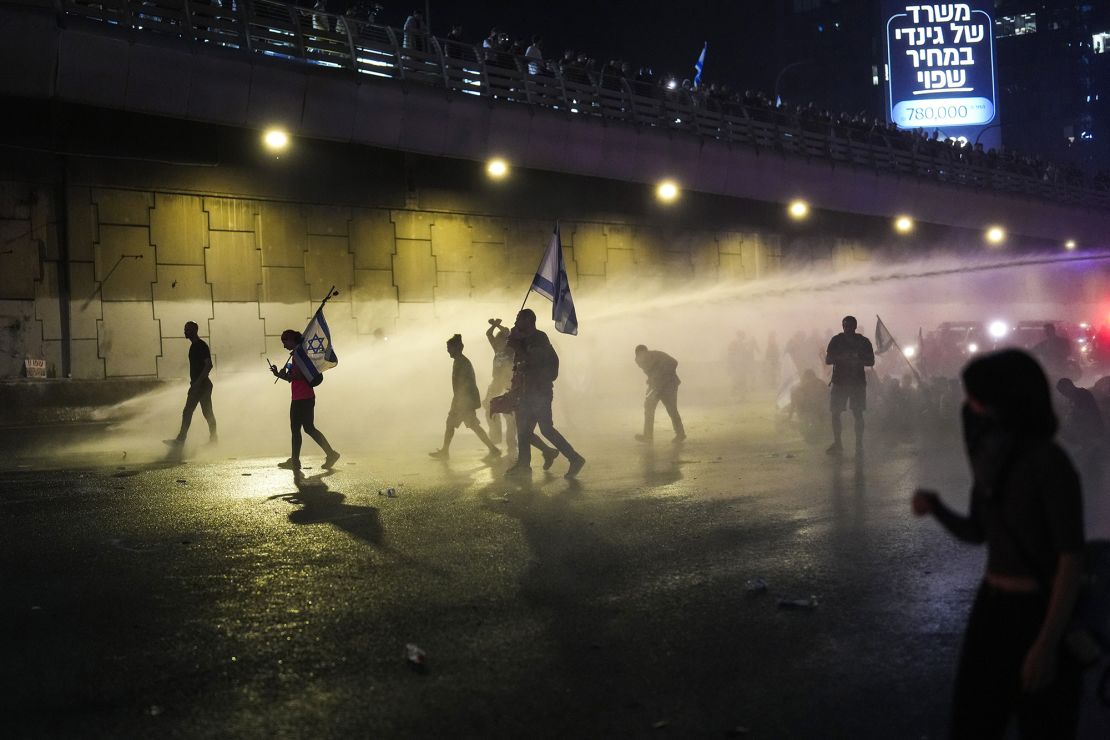 Police use a water cannon to clear a group of people during a protest in Tel Aviv early Wednesday, after it was announced Netanyahu had dismissed Gallant.